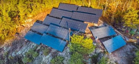 Dronebilde av bakkemontert solcelleanlegg forankret i fjell ved Konsmo